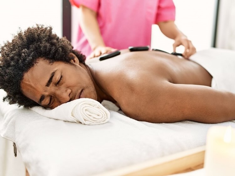 man receiving hot stone massage